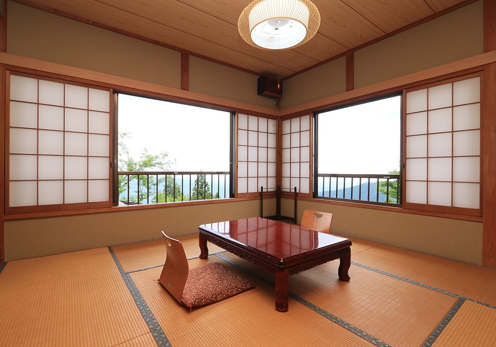窓から山の景色を望む蔵屋の和室